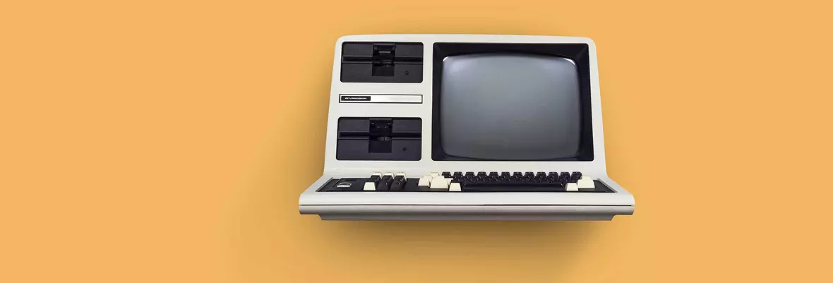 a retro pc from the early 80s on an orange background