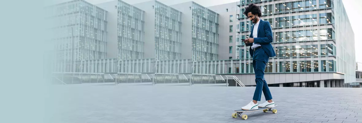 a young man texting on his phone while cruising on a skateboard