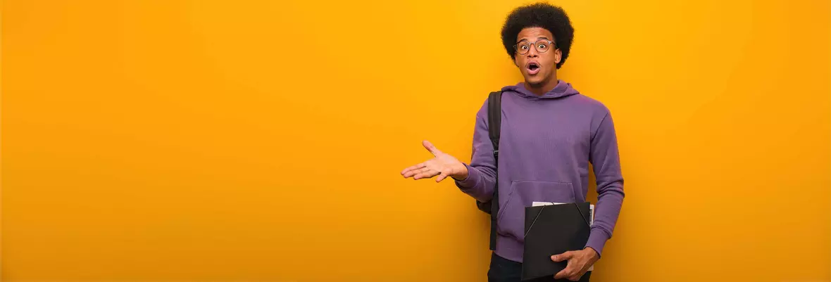 young man in front of orange background looking shocked
