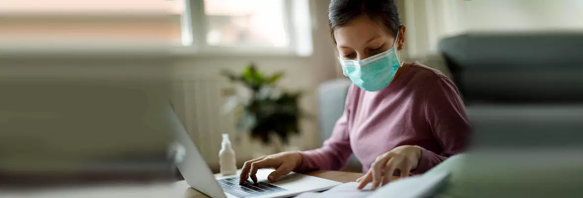 woman behind desk with mask