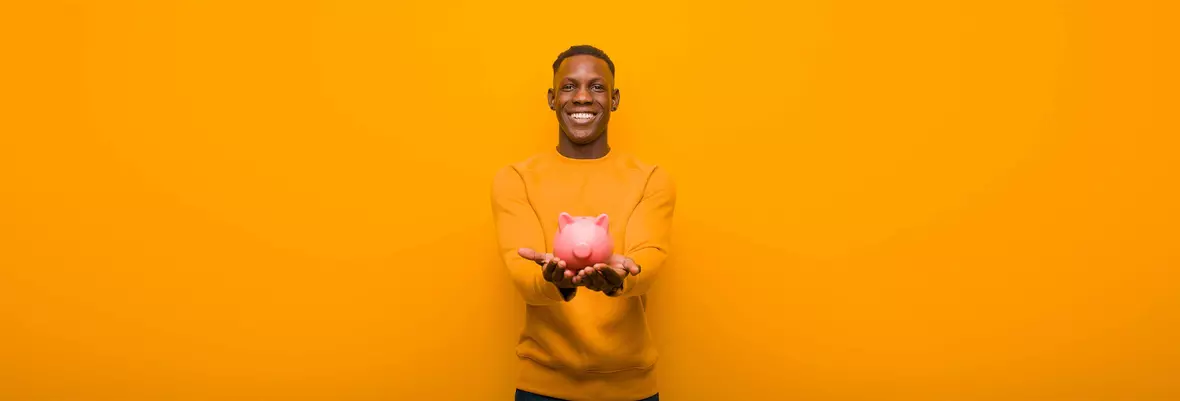 Young man holding a piggy bank