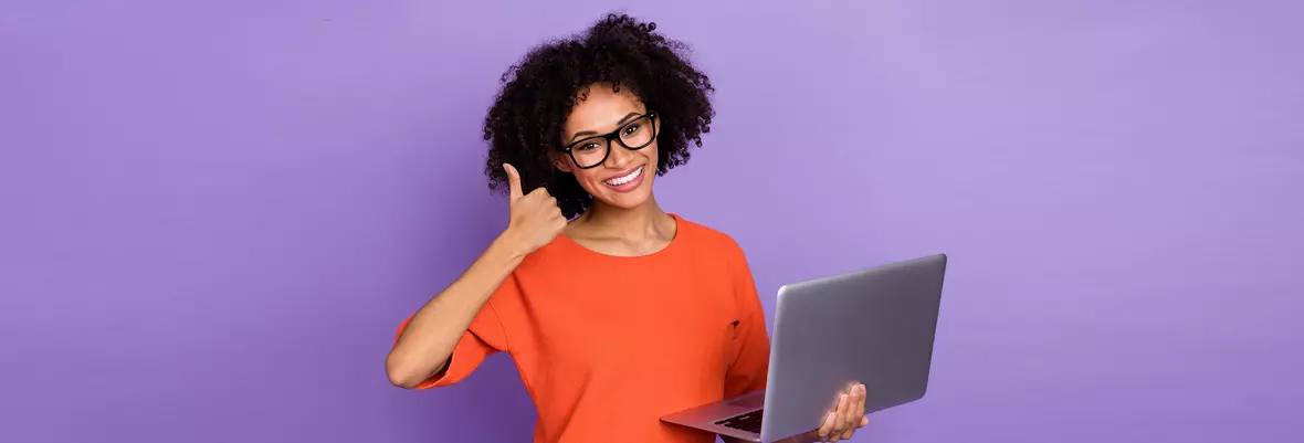 woman with glasses holding laptop with thumbs up