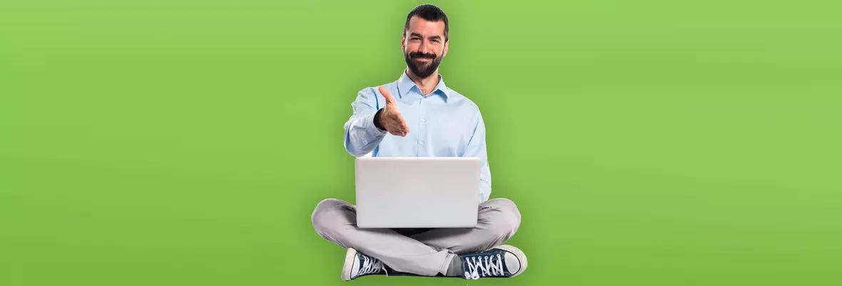 man with laptop sitting cross legged holding up 4 fingers