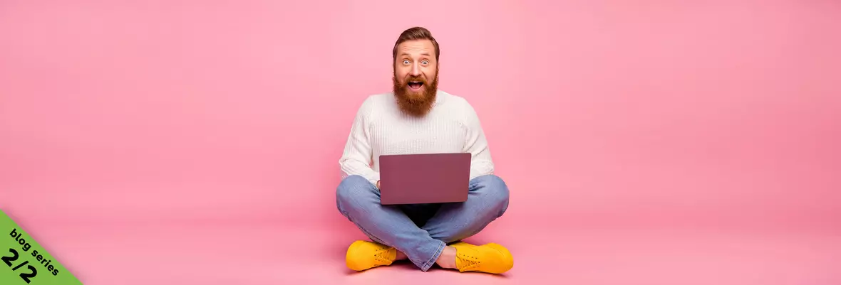 man smiling behind laptop