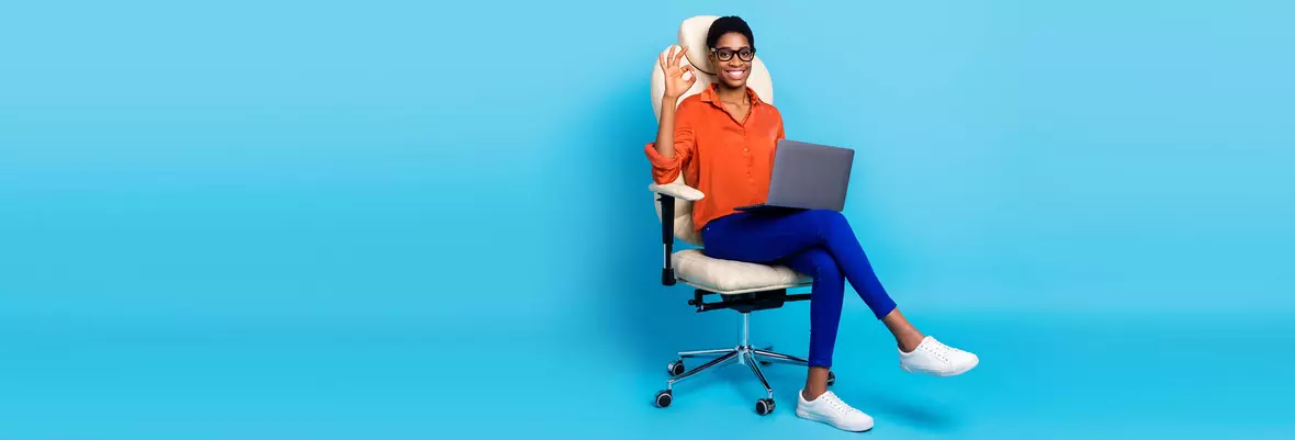 woman sitting on office chair with laptop on lap