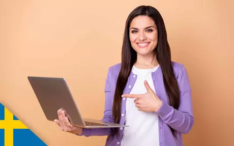 woman, smiling and holding laptop, giving thumbs up sign with free hand an pointing at laptop