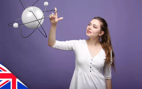 Woman examining a model of an atom with orbiting particles