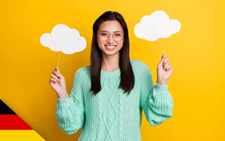 Smiling woman holding up cutout paper clouds