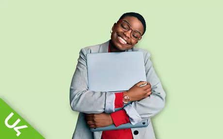 Woman with glasses hugging her laptop happily