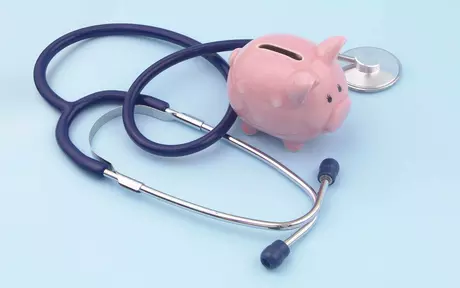 Stethoscope with piggy bank on blue background