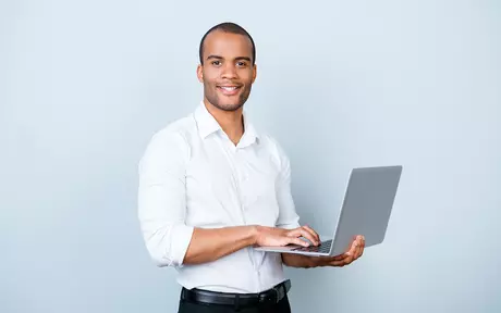 man standing with laptop