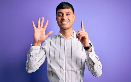 man holding up 6 fingers