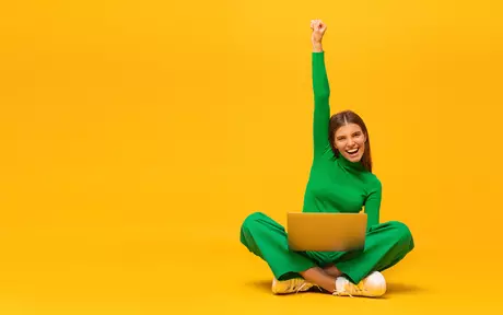 woman in green tracksuit sitting crossed legged with arm up