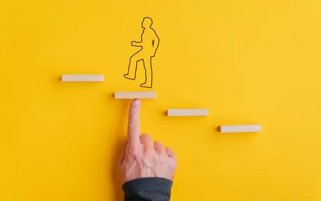 Finger pointing at drawn man going up small steps 