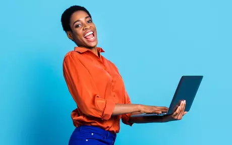 woman smiling holding laptop