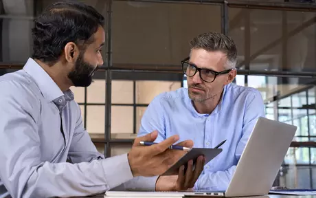 Men talking with laptop