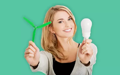 Smiing woman holding a lightbulb and a small fan