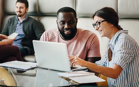 Four individuals in a modern, casual office setting.