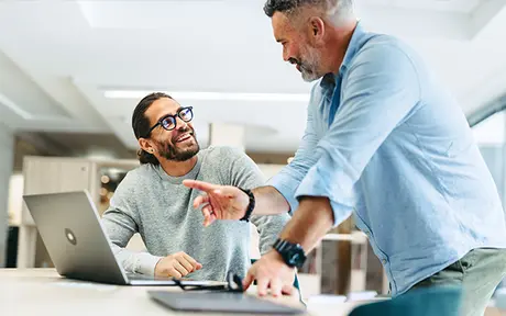 Two men collaborate in a modern office setting. 