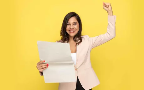 person with paper on yellow background