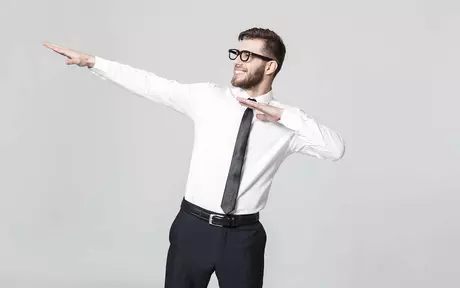 a young smartly dressed man in glasses dabbing