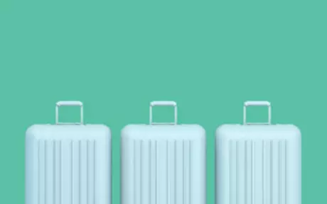 Three blue suitcases on green background