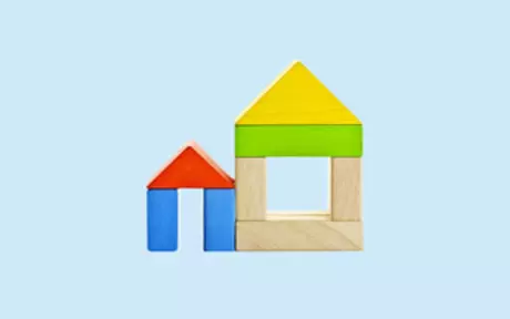 Houses made of wooden blocks on blue background
