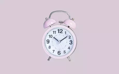Old-fashioned alarm clock on pink background