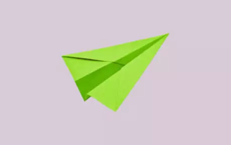 Green paper plane on pink background