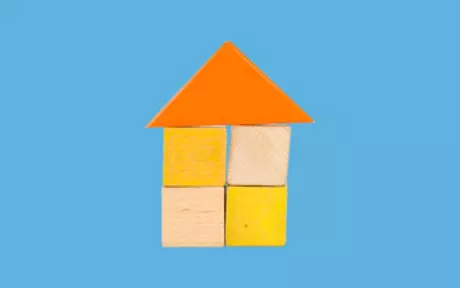House made of wooden blocks on blue background