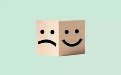 Happy and sad face on wood block