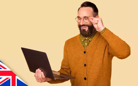 Man with beard and glasses looking at a laptop