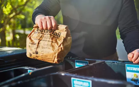 Man throwing food rubbish in bin