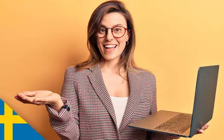 woman, smiling and holding laptop, gesturing with free hand
