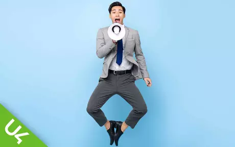 Man holding loud hailer/bullhorn jumping in the air