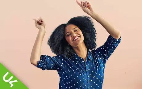 Smiling woman with both arms raised in celebration